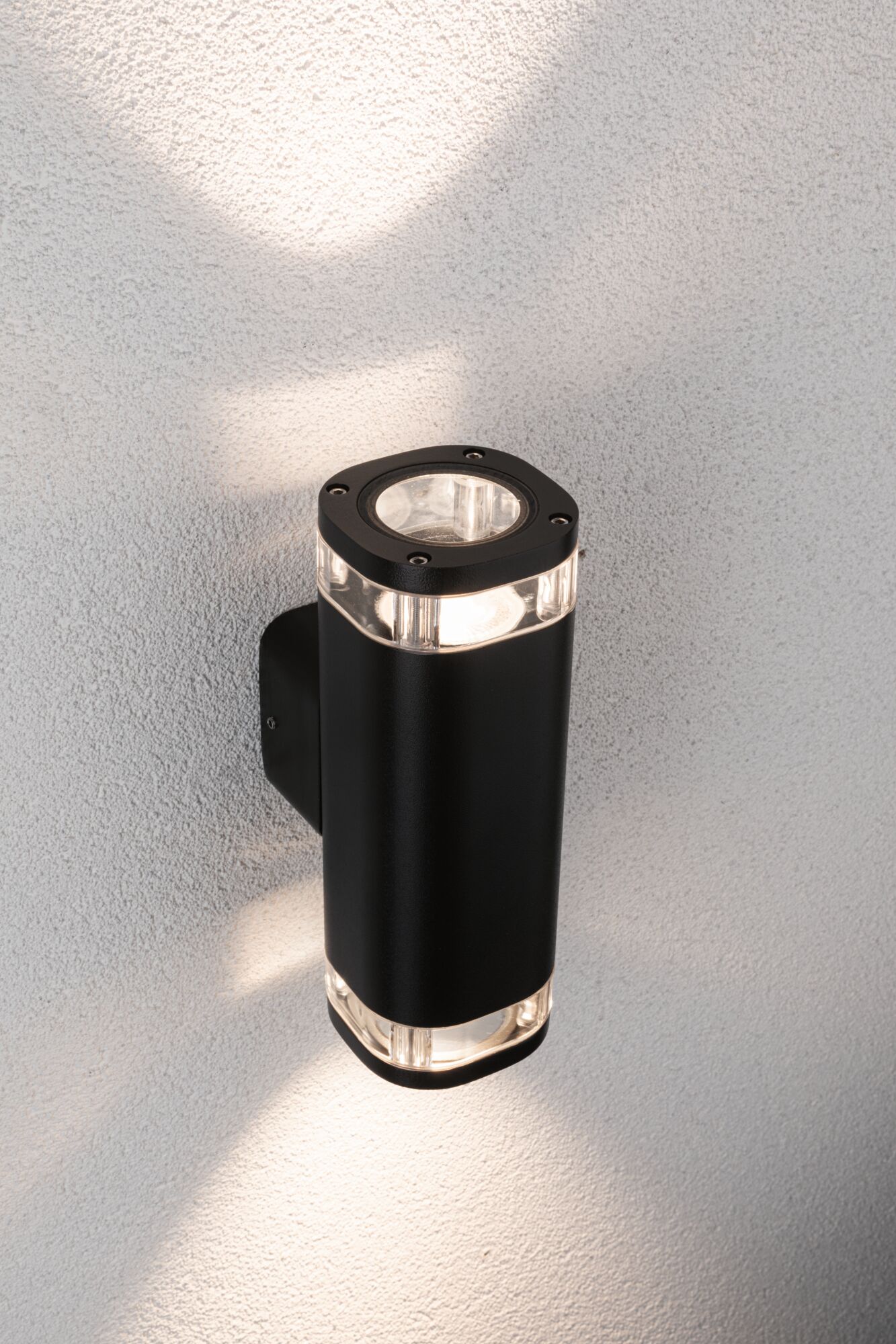 Black aluminum wall light with clear glass elements and warm white LED light for outdoor use.