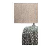 Bordlampe med beige stofskærm og grå keramisk fod med tekstureret mønster til boligbelysning