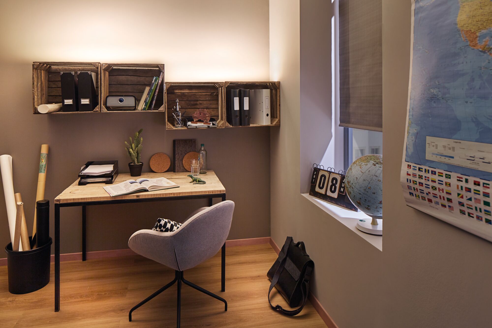 Modernes Arbeitszimmer mit Holzschreibtisch, grauem Stuhl und Wandregalen aus Holz für Büroorganisation
