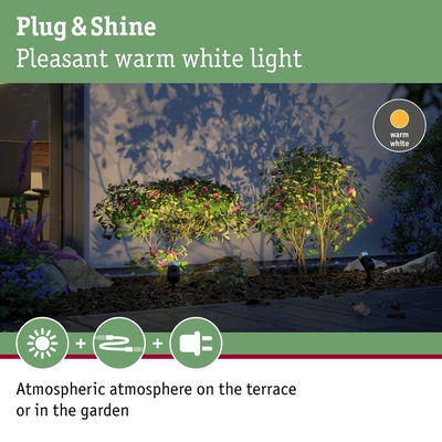 Outdoor spotlights with warm white light illuminating green bushes for atmospheric garden and terrace.