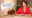 Woman in red shirt beside modern silver LED desk lamp on wooden table with usage duration text.
