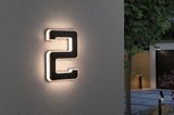 Moderne verlichte huisnummer 2 van zwart materiaal met warm wit LED-licht aan buitenmuur.