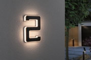 Modern beleuchtete Hausnummer 2 aus schwarzem Material mit warmweißem LED-Licht an Außenwand.