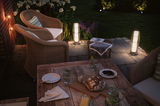 Terrasse confortable avec mobilier en rotin et lampes LED extérieures blanc chaud pour éclairage de jardin.