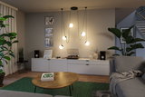 Modern living room lighting with five hanging globe lights in warm white and green cables.
