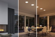 Modern dining room with white chairs and round LED recessed lights emitting warm white light