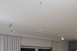 Moderne sølv kabelbelysning med to justerbare LED-spotlights på hvidt loft til stuebelysning