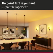 Salon moderne avec suspensions en verre jaune et chaises de salle à manger noires sous éclairage chaud