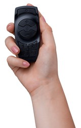 Black plastic remote control with buttons for light control held in hand