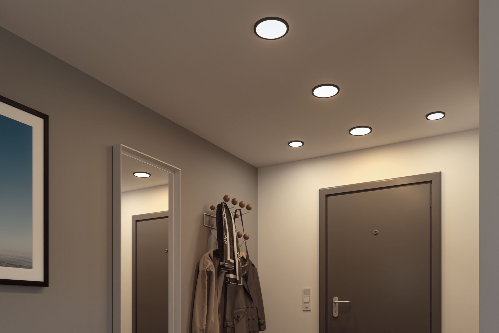 Platte ronde LED-plafondlampen met zwarte rand in moderne hal met kapstok en spiegel.