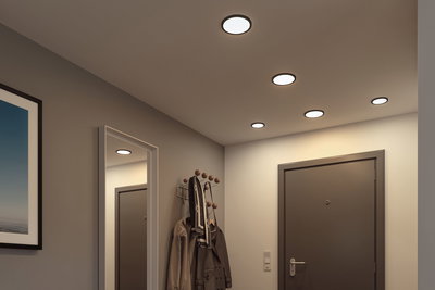 Platte ronde LED-plafondlampen met zwarte rand in moderne hal met kapstok en spiegel.