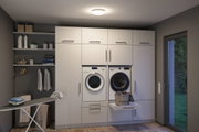 Moderne weiße Einbau-Waschküche mit Waschmaschine, Trockner und integriertem Wäschekorb in Schublade