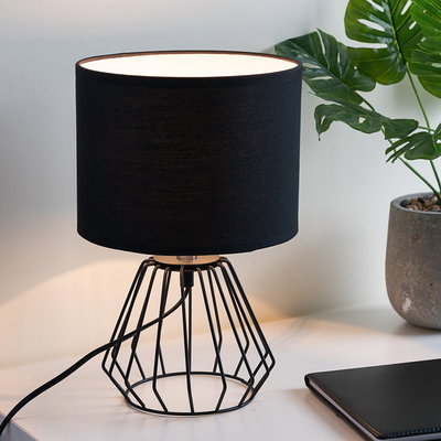 Moderne Tischlampe mit schwarzem Stoffschirm und geometrischem Metallgestell für stilvolle Raumbeleuchtung
