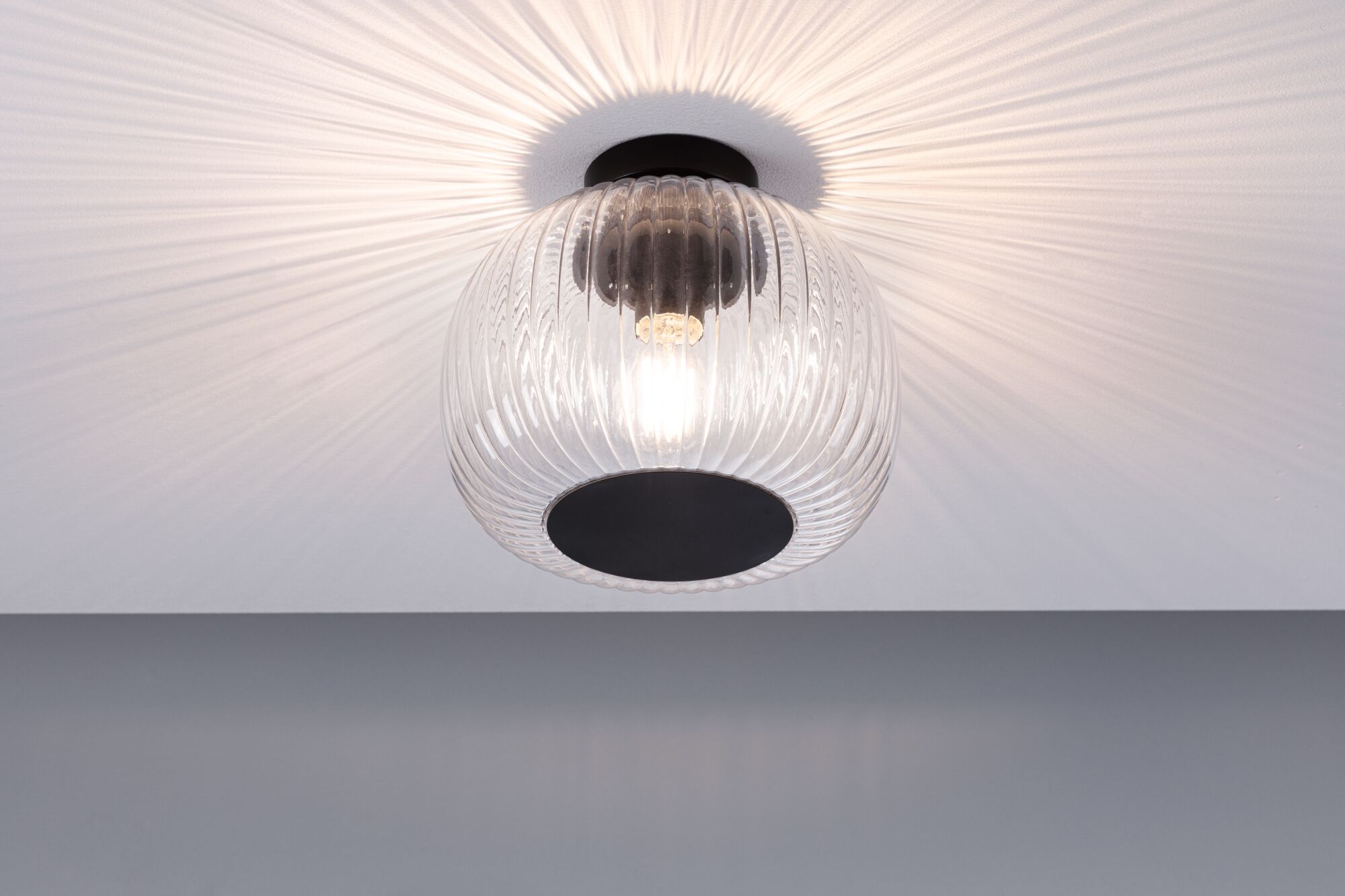 Ceiling light with ribbed clear glass and black metal base, modern indoor lighting fixture
