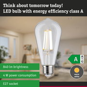 Clear LED bulb with warm white light and ultra-efficient energy use against green forest background