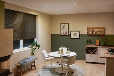 Moderne keuken met ronde witte tafellamp en warmwitte LED-plafondspots voor sfeervolle verlichting.