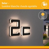 Numéro solaire 2c en matériau noir avec lumière LED blanc chaud sur mur gris