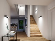 Modern hallway with wooden stairs and black LED wall lights for ambient home lighting