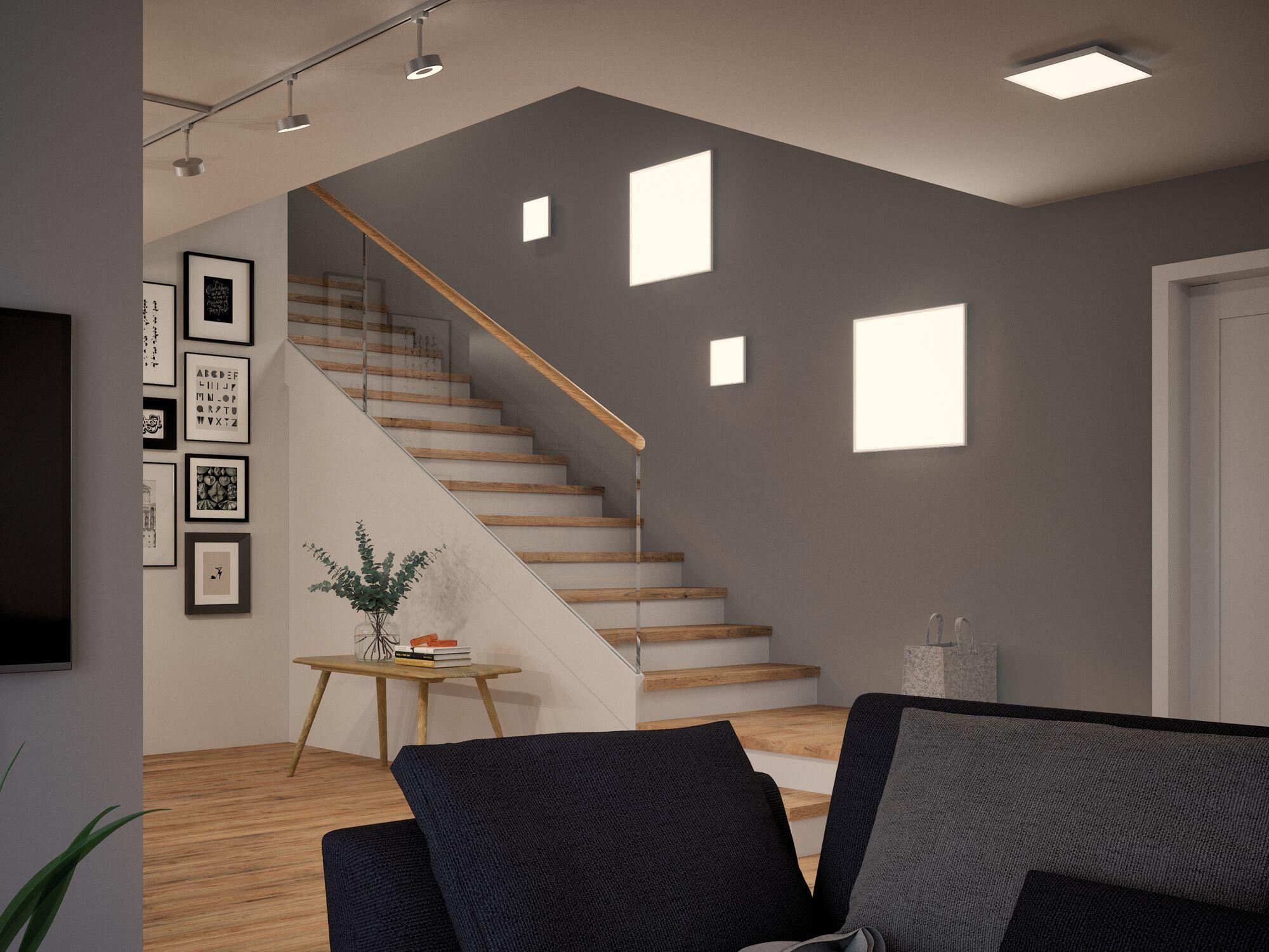 Modern living room with wooden stairs, grey wall, and square LED wall lights for ambient home lighting.