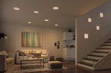 Modern living room with warm white LED ceiling lights and square wall lamps by staircase.