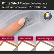Doigt réglant la couleur blanche de la lumière sur lampe LED plafond avec cadre en bois – éclairage dimmable