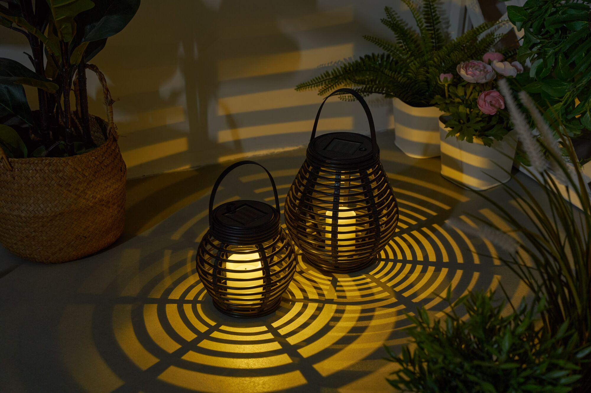 Twee zwarte metalen solar-lantaarns met warm wit LED-licht en decoratieve schaduwpatronen