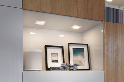 Lumières LED blanches modernes sous meuble dans étagère de cuisine avec haut-parleur et cadres photo