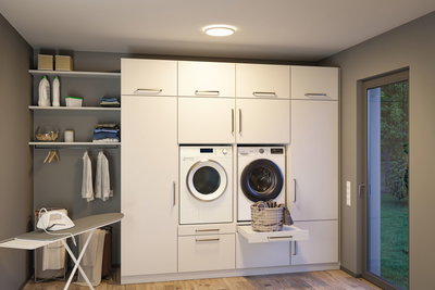 Moderne hvidt indbygget vaskemaskine og tørretumbler i gråt vaskerum med LED-loftlys.