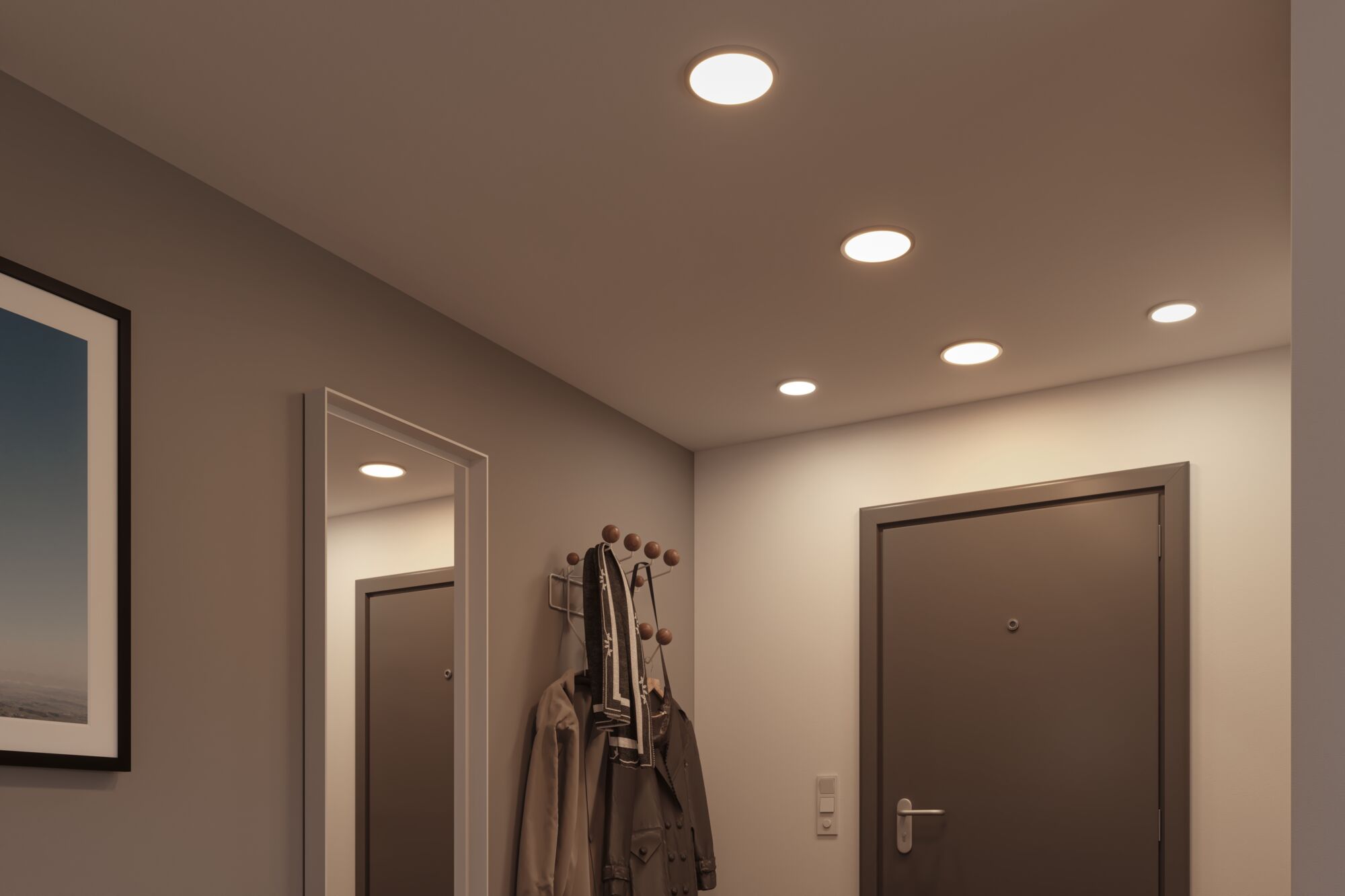 Platte witte LED-inbouwspots in plafond van moderne hal met grijze deur en kapstok