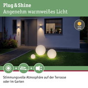 Leuchtende Kugeln mit warmweißem Licht auf Rasen vor modernem Haus für Gartenbeleuchtung