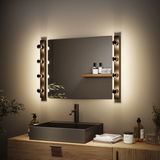 Modernes Badezimmer mit schwarzem Waschbecken, Holzunterschrank und warmweißen LED-Wandleuchten neben Spiegel