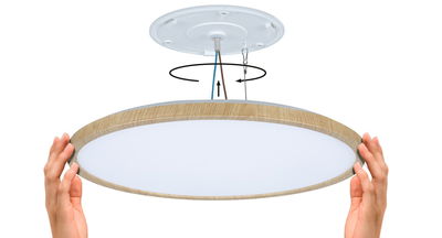 Round ceiling light with wooden frame and white diffuser, shown with installation cables and hands.