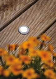 Ronde LED inbouwvloerlicht van geborsteld aluminium in zilver op houten terras met bloemen