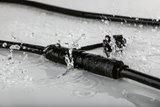 Connecteur de câble noir étanche avec éclaboussures d'eau, composant de connexion électrique robuste