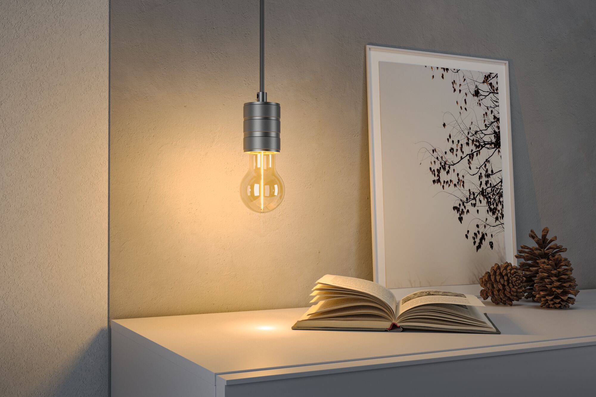 Moderne LED-hanglamp met grijze metalen fitting boven witte tafel met boek en decoratie.