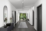 Moderner Flur mit grauem Holzboden, weißen Wänden und minimalistischer Deckenbeleuchtung mit LED-Strahlern
