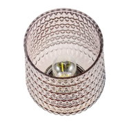 Close-up of pink textured glass lamp with visible bulb for decorative indoor lighting