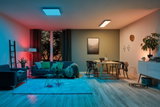 Salon moderne avec plafonniers LED bleu et blanc chaud, sol en bois et mobilier confortable