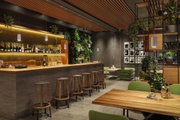 Modernes Barinterieur mit Holztheke, grünen Sitzmöbeln und hängenden weißen Pendelleuchten für Gastronomiebeleuchtung.