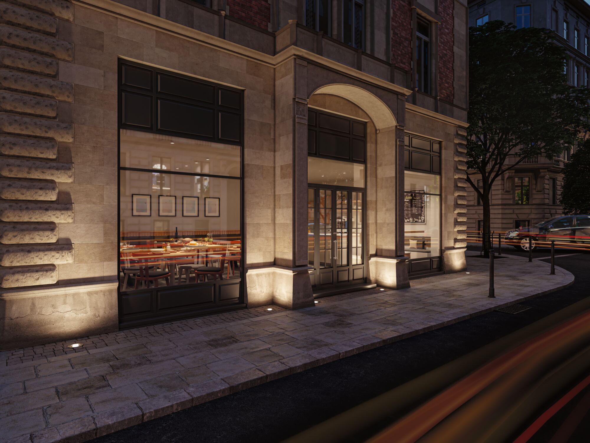 Außenbeleuchtung mit warmweißen LED-Bodeneinbauleuchten an Sandsteinfassade eines Restaurants.