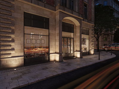 Außenbeleuchtung mit warmweißen LED-Bodeneinbauleuchten an Sandsteinfassade eines Restaurants.