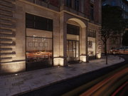 Façade éclairée d'un restaurant en grès avec grandes fenêtres au crépuscule en ville