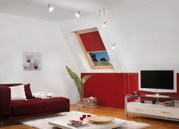 Modern living room with red sofa, white rug, and adjustable cable suspension ceiling lights
