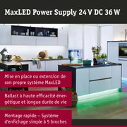 Cuisine blanche moderne avec éclairage LED vert sous les meubles et îlot avec four et plantes