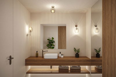 Salle de bain moderne avec meuble en bois, vasque blanche et appliques murales en verre blanc chaud.