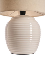 Table lamp with cream ceramic base and beige fabric shade for cozy home lighting