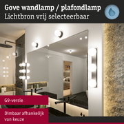 Gove wandlamp met witte glazen bollen bij spiegel in moderne badkamer met zwarte wastafel