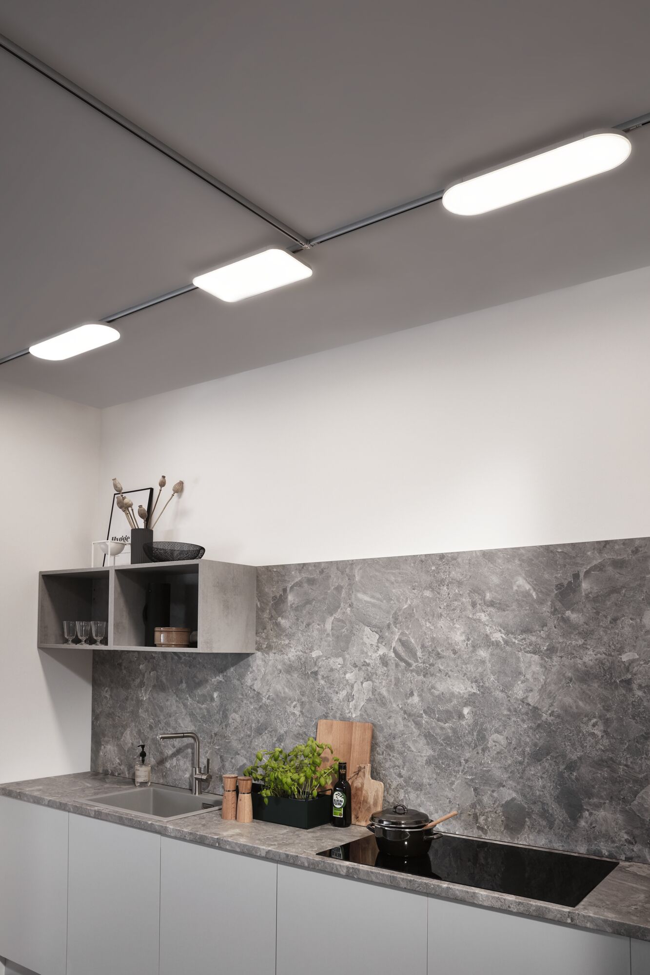 Moderne Küche mit grauer Steinarbeitsplatte und LED-Deckenleuchten für effiziente Beleuchtung