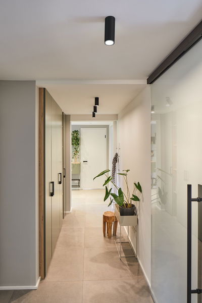 Moderne gang med sorte metalloftspotter og minimalistisk indretning til stilfuld boligbelysning