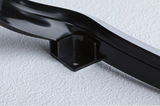 Black plastic mounting bracket with screw hole on white surface for LED light fixture